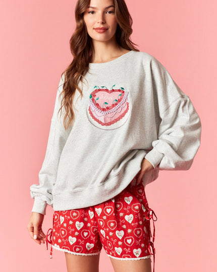 
Oversized embroidered sweatshirt with playful cake design and relaxed fit, styled with heart print shorts