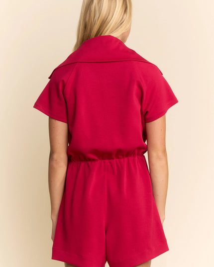 Red romper worn by a person on a beige background
