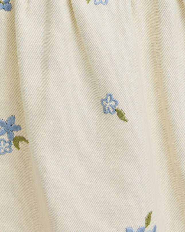 Close-up of beige fabric with small blue floral patterns