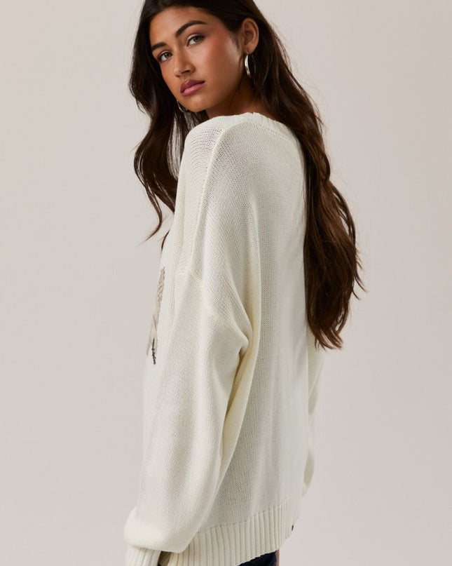 side view of solid colored sleeve cream swan knit sweater with bird design from Calli’s Curations boutique