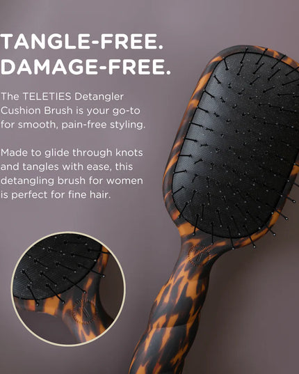 TELETIES Detangler Cushion Brush with tortoiseshell handle on a dark background