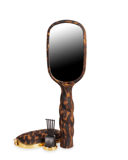 Handheld mirror with tortoiseshell handle on a white background