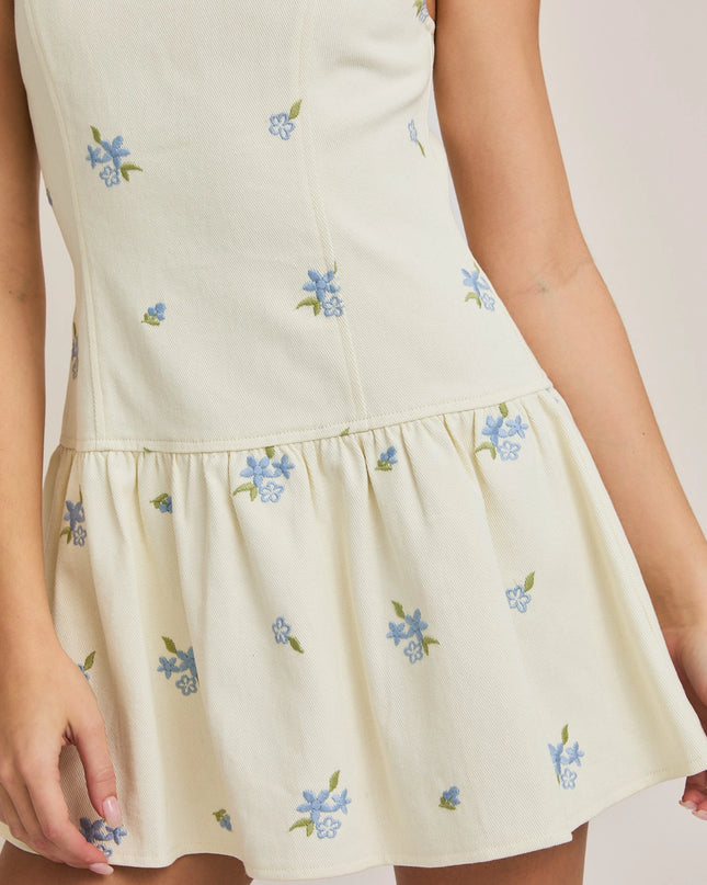 White dress with floral embroidery on a plain background