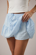 Light blue shorts worn by a person on a neutral background