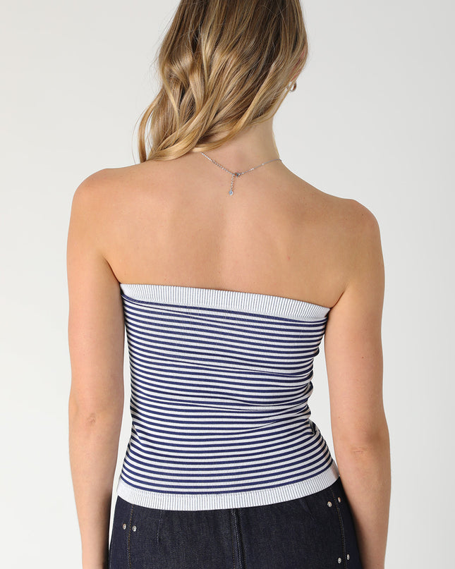 Woman wearing a strapless striped top with a plain background