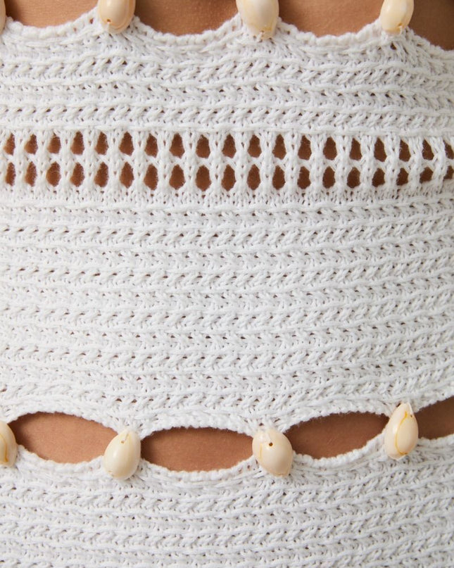 Close-up of a textured white fabric with shell-like embellishments.