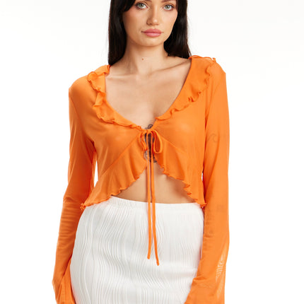 Model wearing Citrus Glow Ruffle Tie Front Top in bright orange with long sleeves and ruffle trim – Calli’s Curations boutique