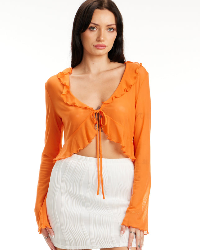 Model wearing Citrus Glow Ruffle Tie Front Top in bright orange with long sleeves and ruffle trim – Calli’s Curations boutique