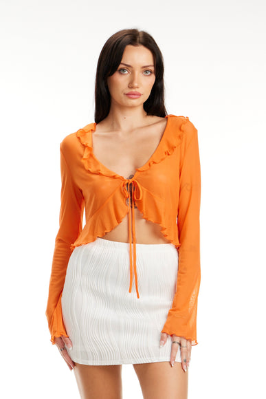 Model wearing Citrus Glow Ruffle Tie Front Top in bright orange with long sleeves and ruffle trim – Calli’s Curations boutique