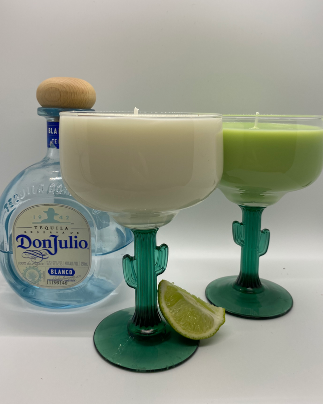 green and white candles in a cactus handle margarita glass next to a bottle of don julio