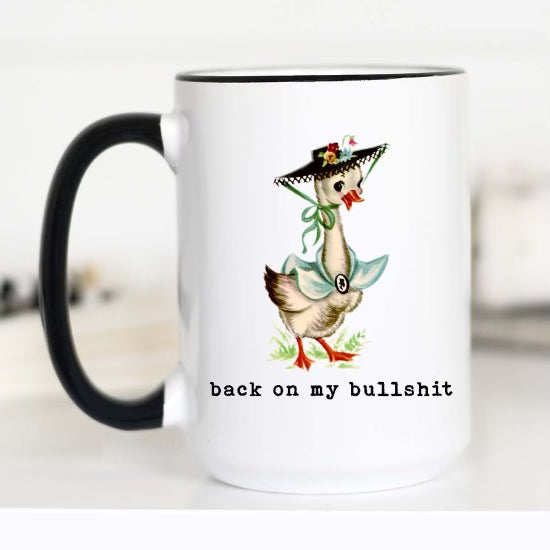 mug with black handle with  a good in a bonnet and the font says "back on my bullshit"