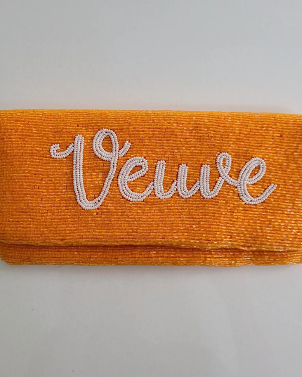 Orangish-yellow clutch beaded all over with white script that says "Veuve in cursive"